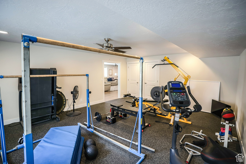 Exercise area with a textured ceiling and ceiling fan