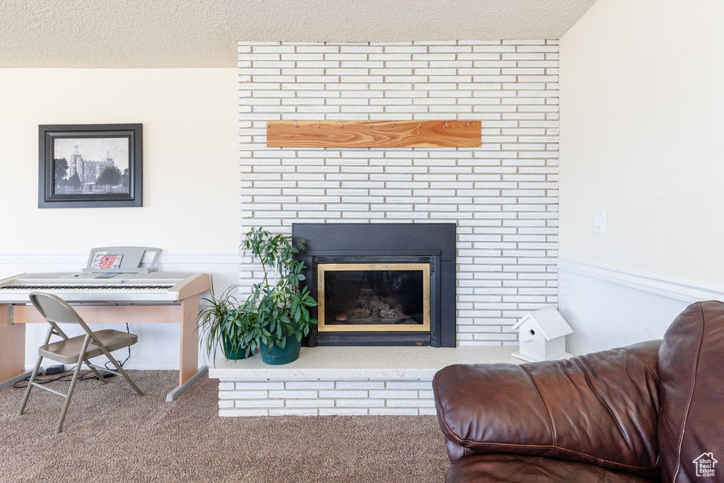 Living room featuring a brick fireplace and a textured ceiling