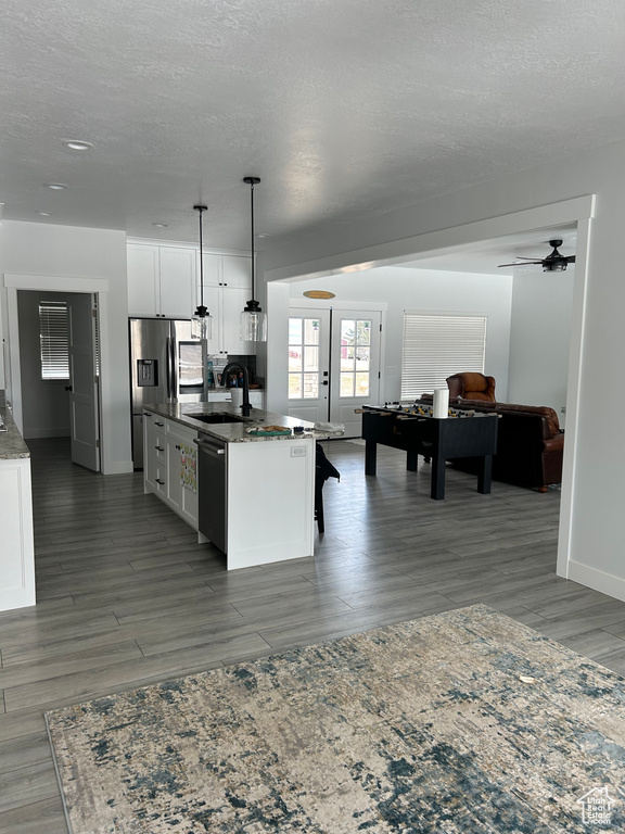 Kitchen with french doors, white cabinets, pendant lighting, stainless steel dishwasher, and ceiling fan