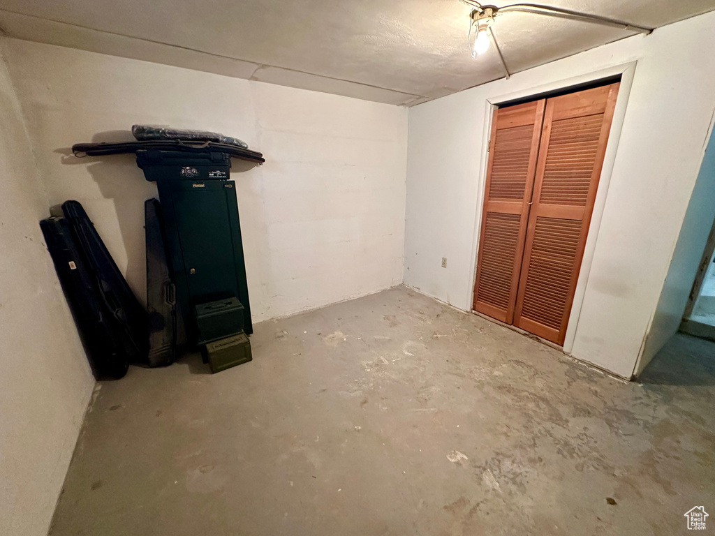 Unfurnished bedroom with concrete flooring and a closet