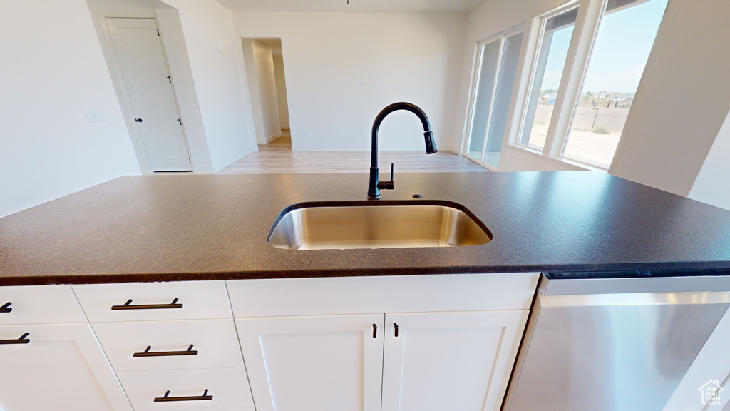 Kitchen with sink, white cabinetry, and stainless steel dishwasher