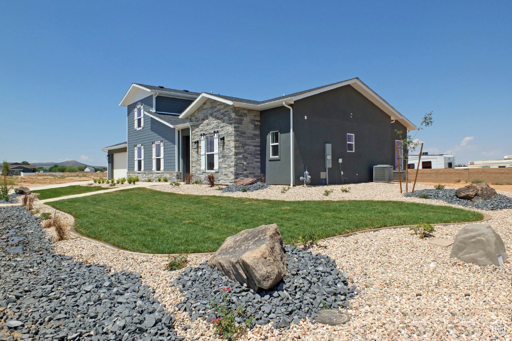 Exterior space featuring a front lawn and central AC unit