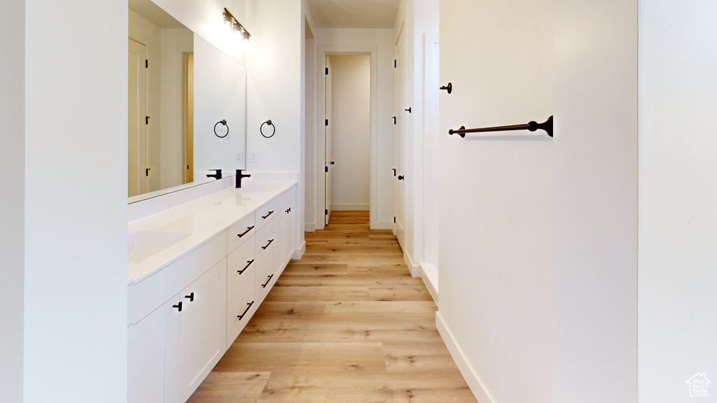 Bathroom with dual vanity and wood-type flooring