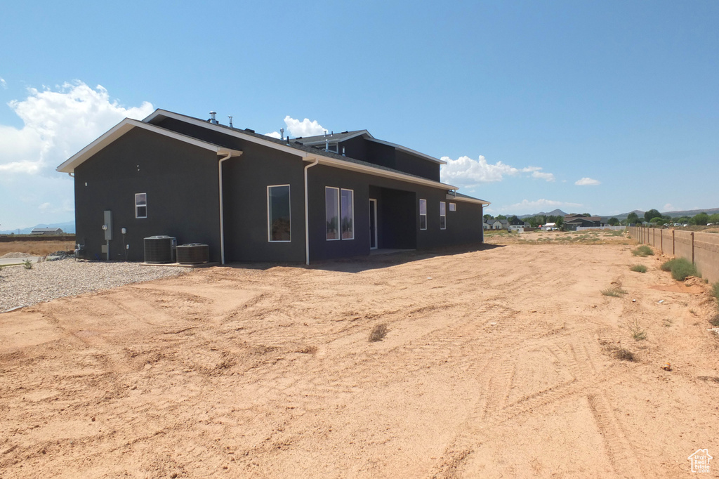 Back of house with central AC unit