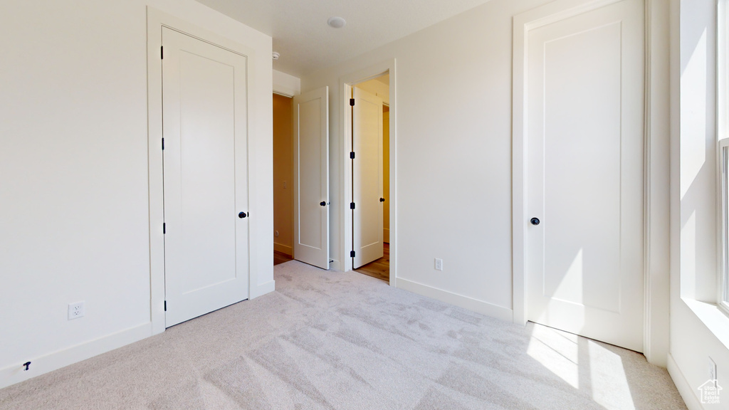 Unfurnished bedroom with light carpet