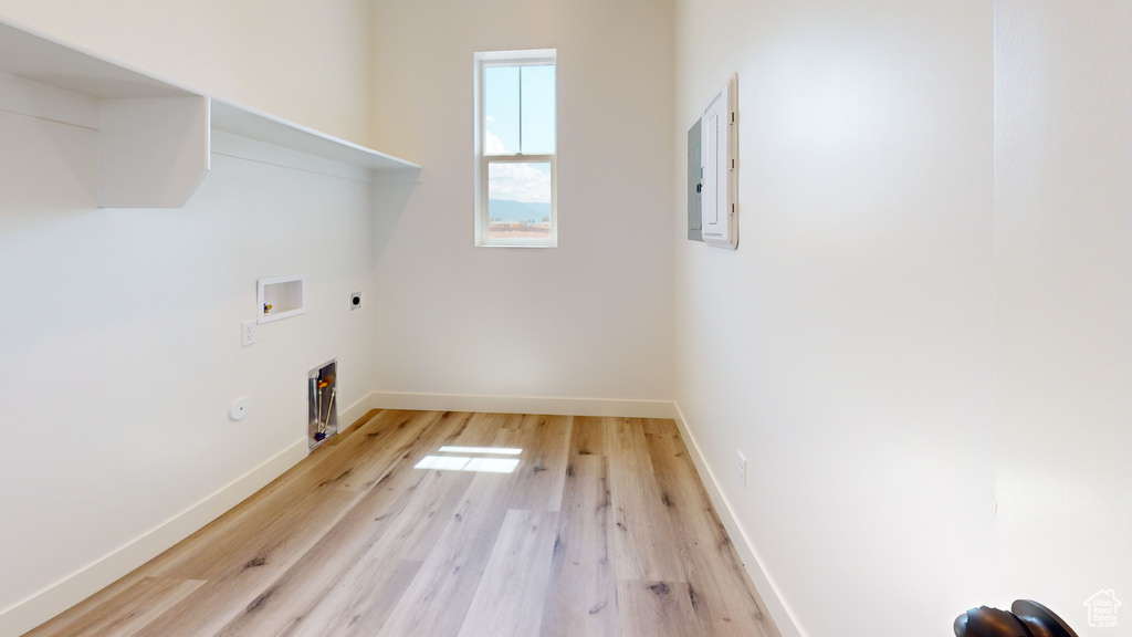 Washroom with hookup for a washing machine, hookup for an electric dryer, gas dryer hookup, and light hardwood / wood-style floors