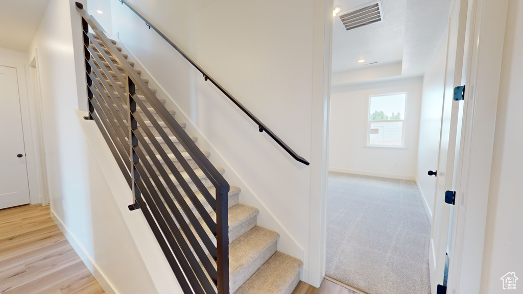 Stairway featuring hardwood / wood-style flooring