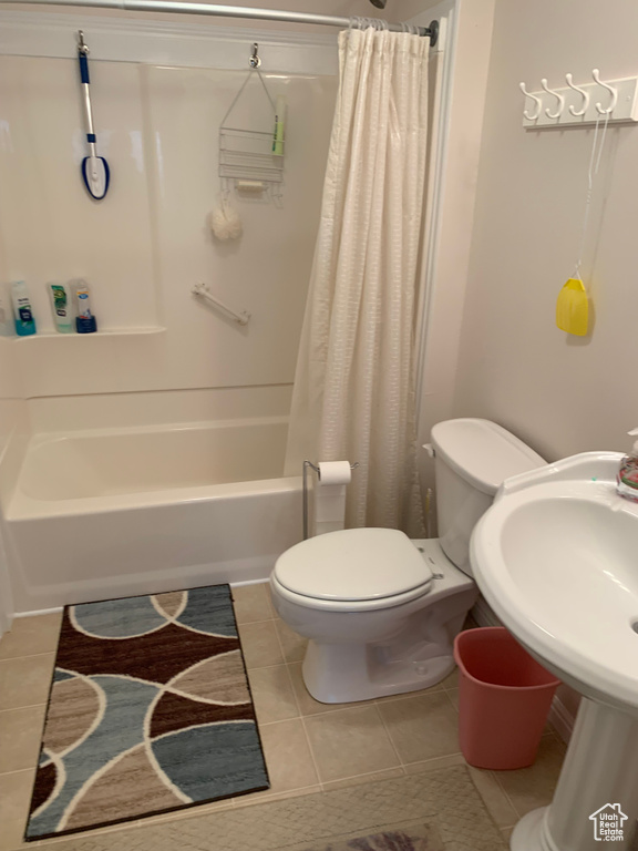 Bathroom with toilet, shower / bath combination with curtain, and tile floors