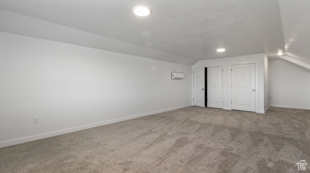 Bonus room with carpet floors and vaulted ceiling