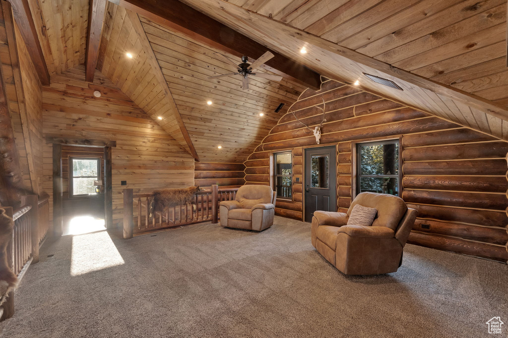 Unfurnished living room with rustic walls, ceiling fan, carpet, and wood ceiling