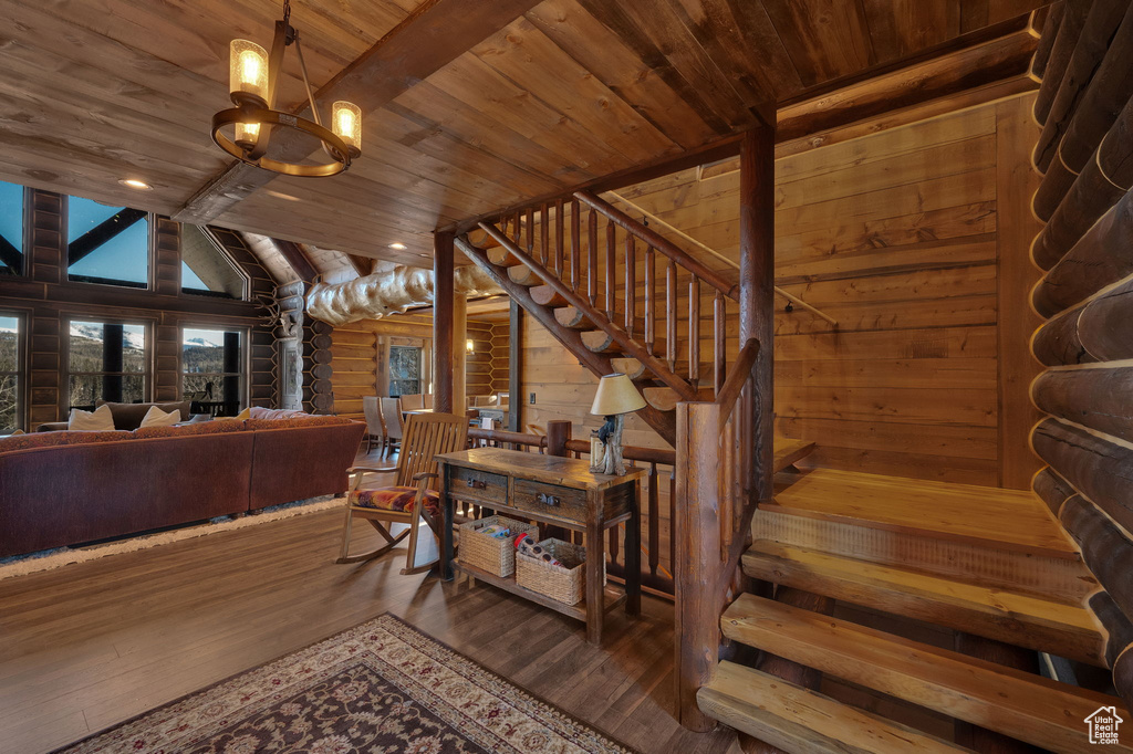Stairs featuring dark hardwood / wood-style flooring, a chandelier, wood ceiling, and lofted ceiling with beams