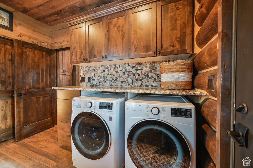 Laundry room with dark hardwood / wood-style flooring, cabinets, wooden ceiling, and washing machine and clothes dryer