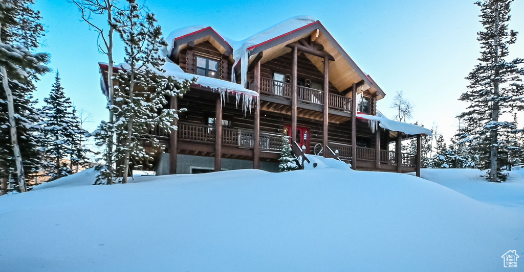 Snow covered property with a balcony