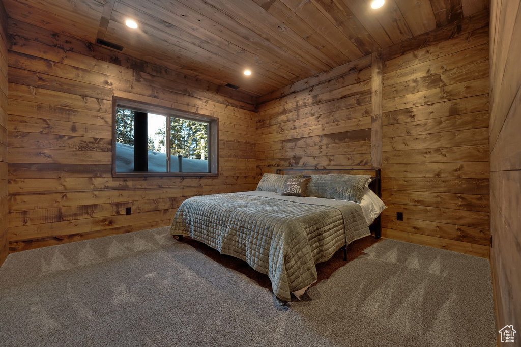 Bedroom featuring wooden walls, carpet floors, and wooden ceiling