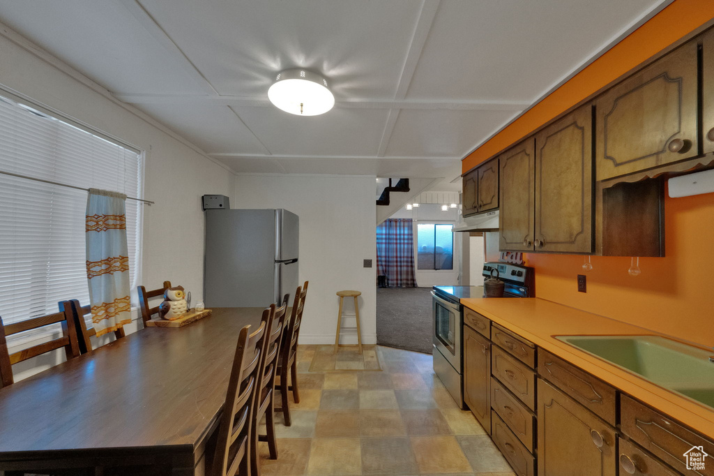 Kitchen with light tile floors, white fridge, and electric range