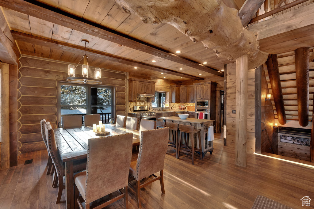 Dining room with dark hardwood / wood-style flooring, rustic walls, a notable chandelier, and wood ceiling