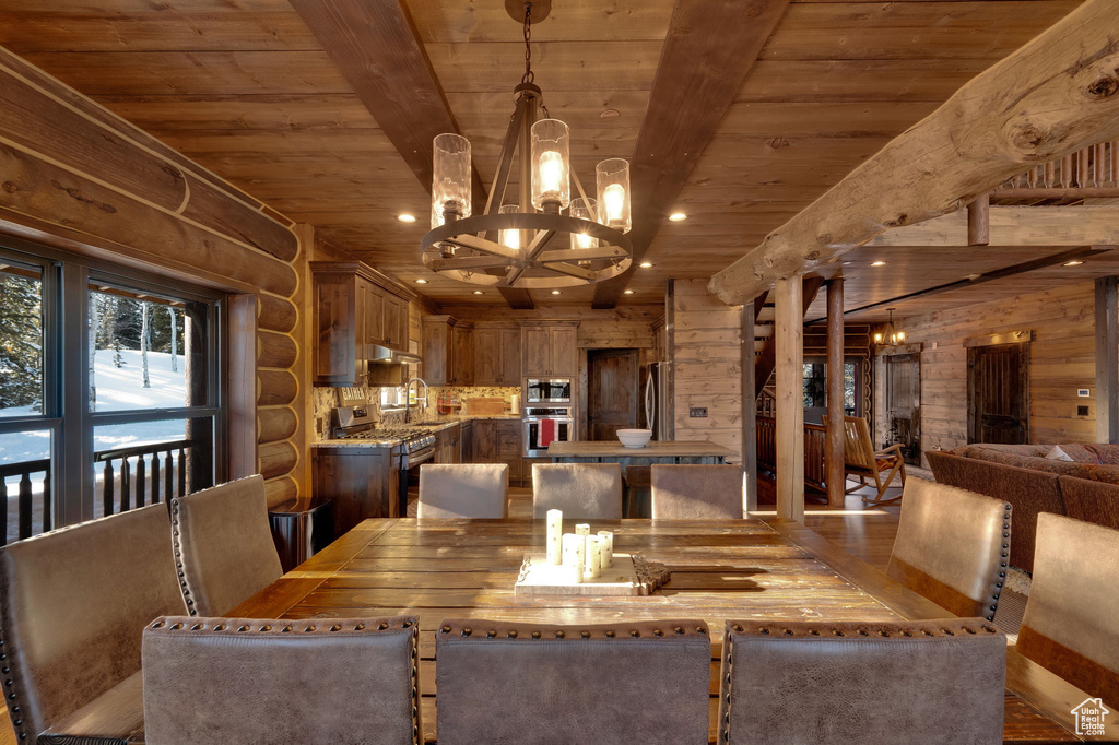 Dining area featuring hardwood / wood-style flooring, a chandelier, beam ceiling, and wooden ceiling
