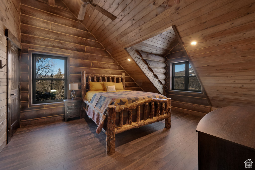 Bedroom featuring lofted ceiling, ceiling fan, wooden ceiling, dark wood-type flooring, and wood walls