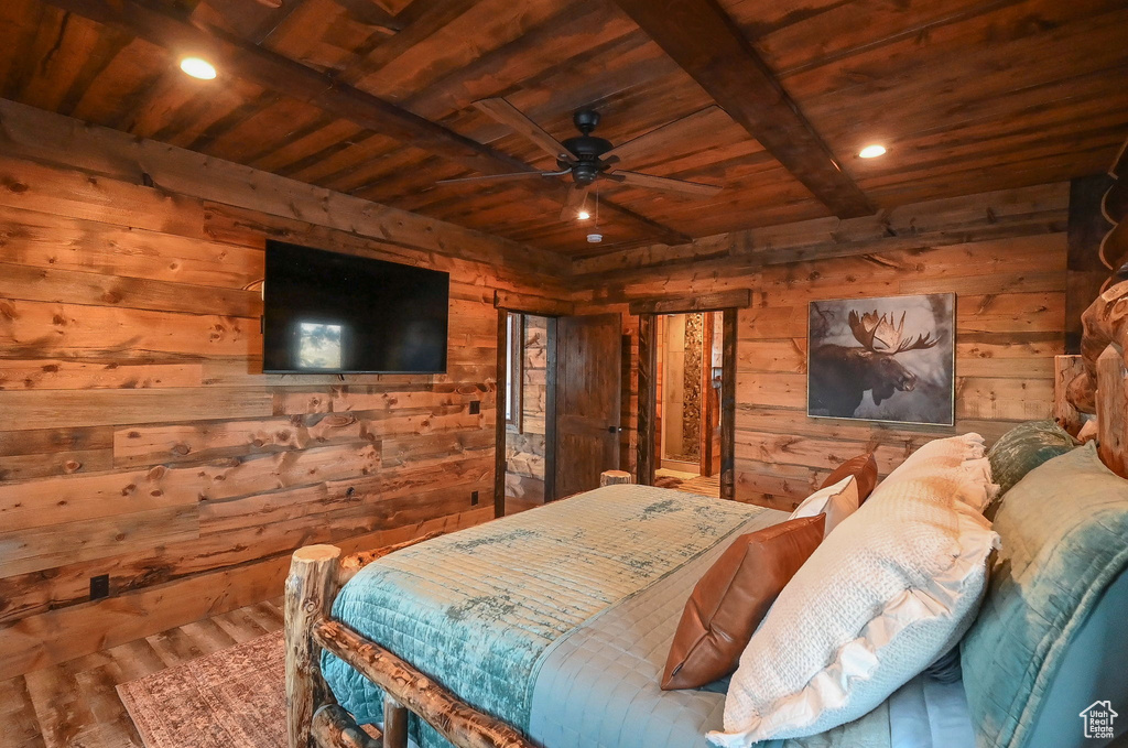 Bedroom with dark hardwood / wood-style floors, wood walls, beam ceiling, wooden ceiling, and ceiling fan
