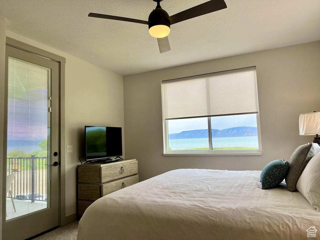 Bedroom featuring a mountain view, carpet floors, access to exterior, and ceiling fan