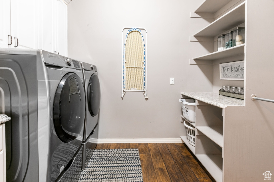 Laundry area with cabinets, dark hardwood / wood-style floors, and washer and dryer