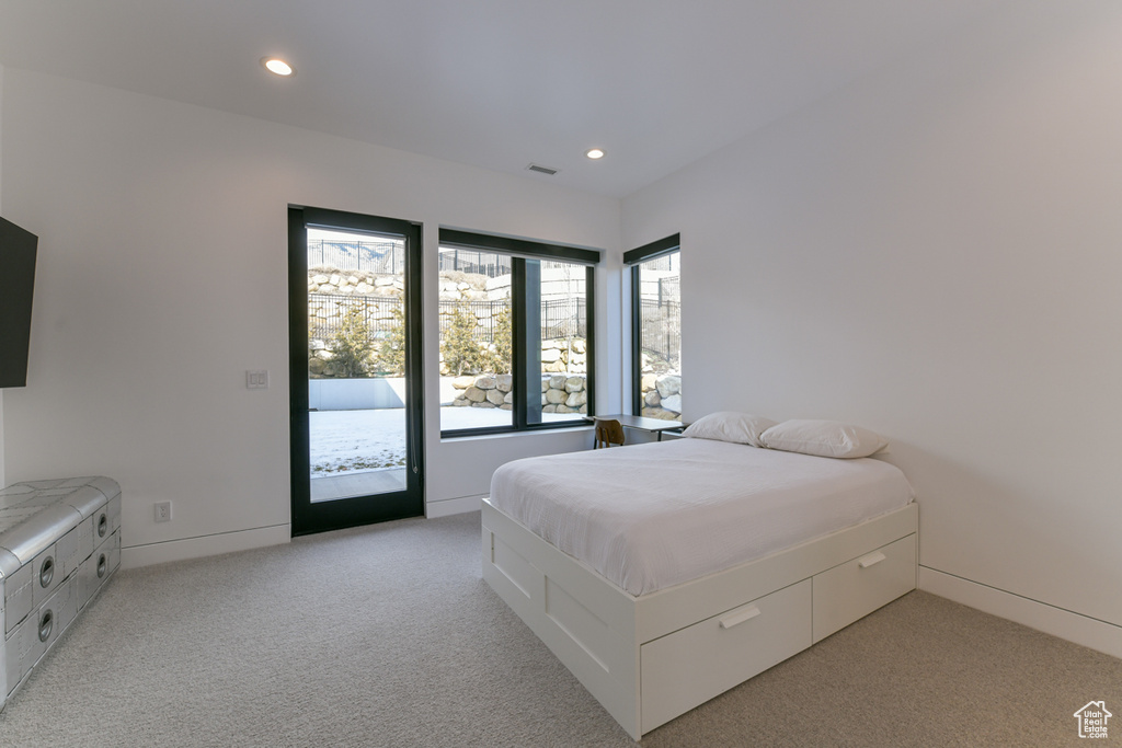 Bedroom featuring access to outside, multiple windows, and light carpet