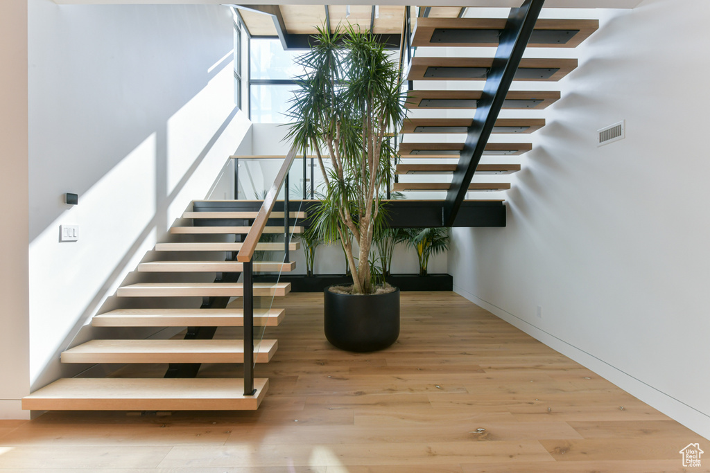 Stairway with light hardwood / wood-style floors