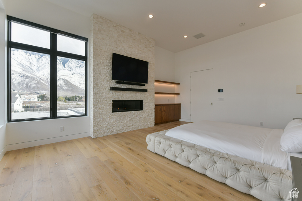 Bedroom with light hardwood / wood-style flooring and a fireplace