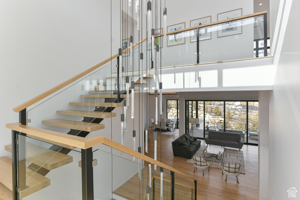 Stairway featuring a high ceiling and light hardwood / wood-style floors
