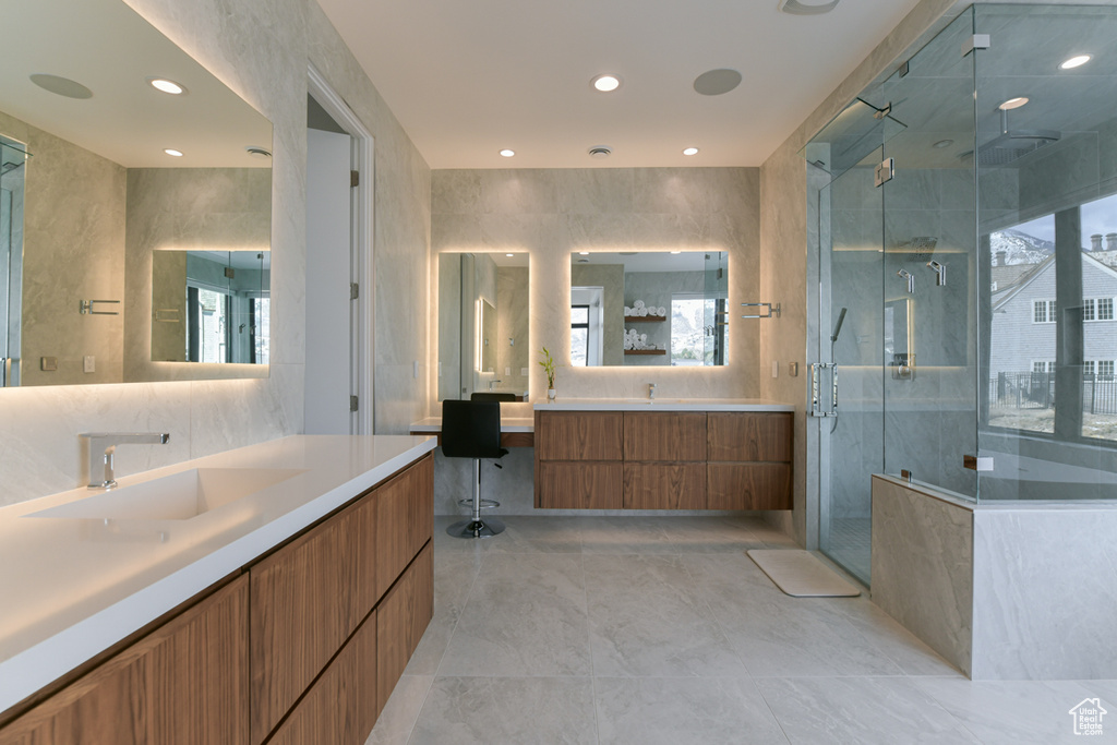 Bathroom featuring vanity, walk in shower, tile walls, and tile flooring
