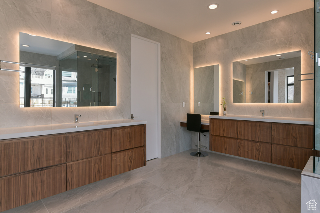 Bathroom with vanity, tile flooring, and tile walls