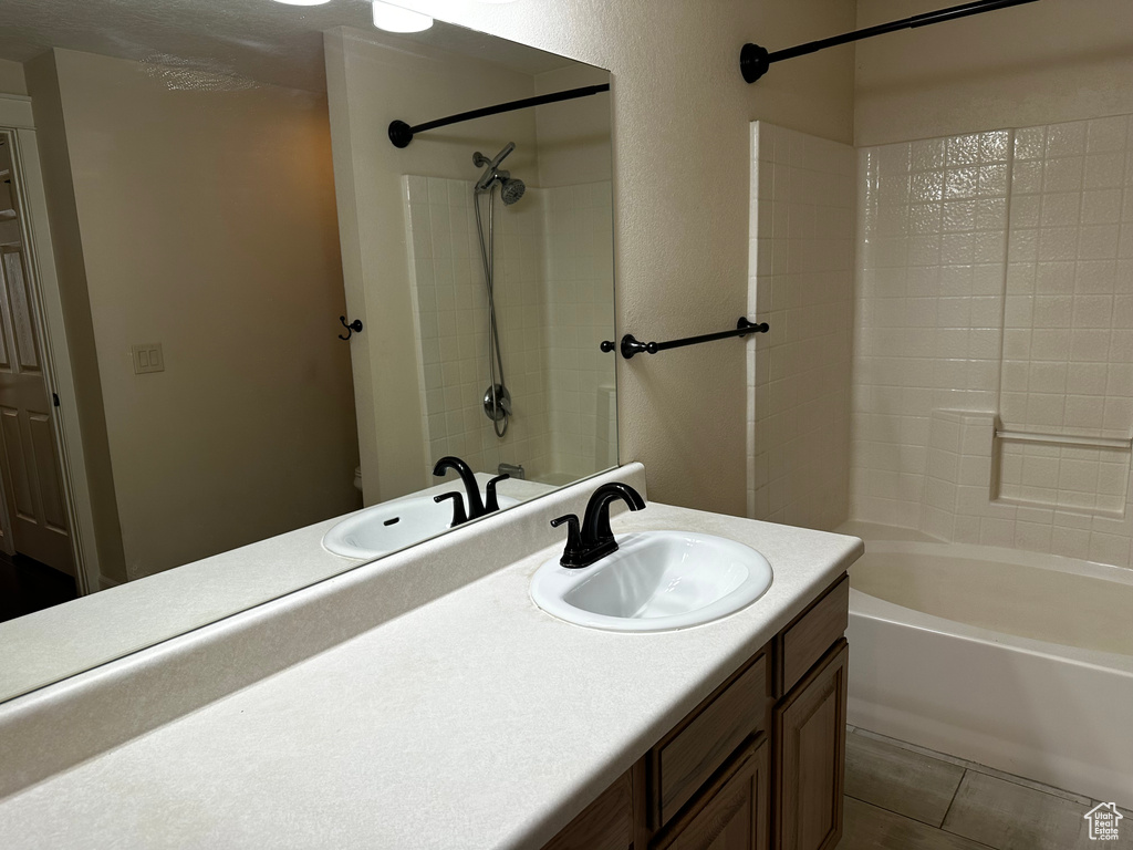 Bathroom with vanity, washtub / shower combination, and tile floors
