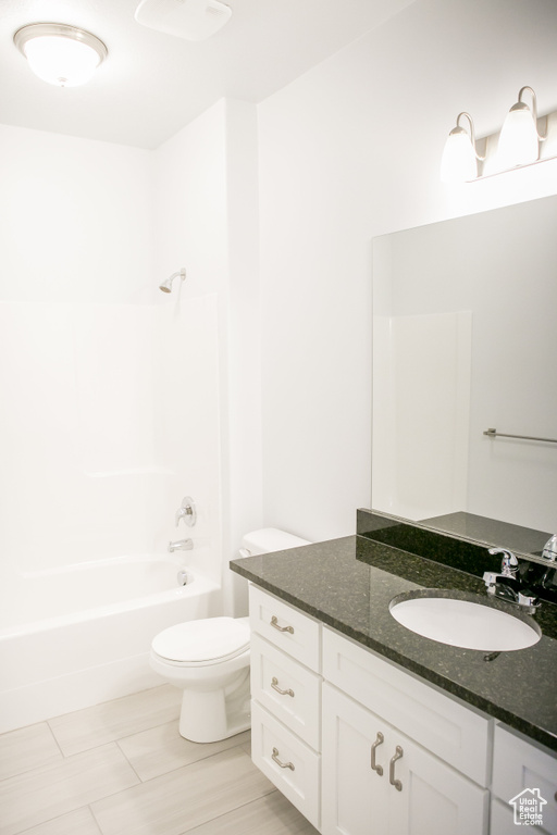 Full bathroom featuring vanity, toilet, tile flooring, and shower / bathtub combination