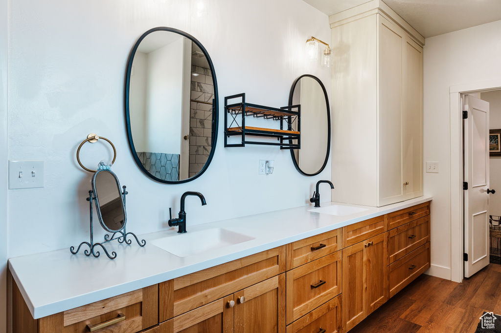 Bathroom featuring dual bowl vanity and hardwood / wood-style floors