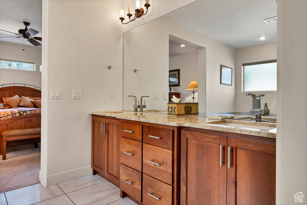 Bathroom with tile flooring, large vanity, dual sinks, and ceiling fan