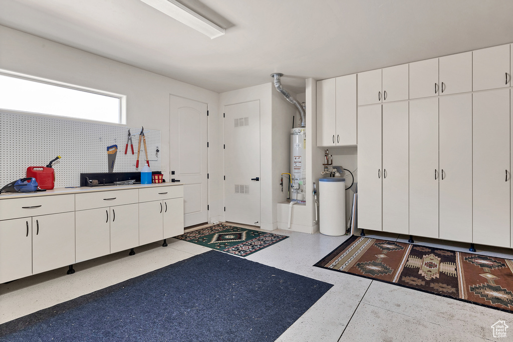 Interior space featuring white cabinetry and gas water heater