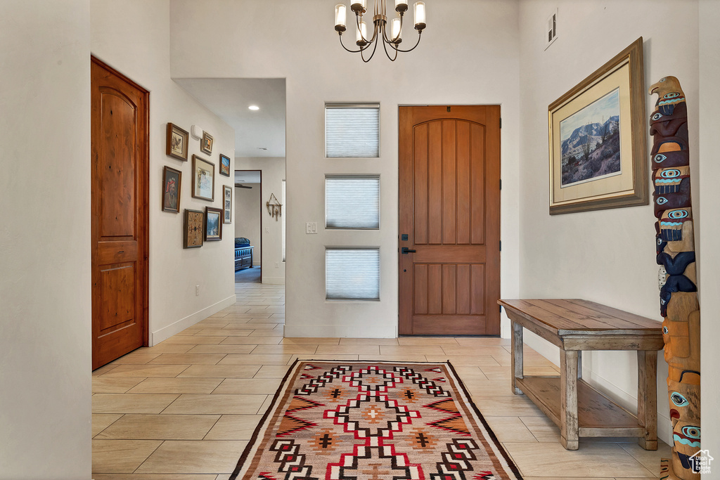 Entryway featuring a notable chandelier and light tile floors