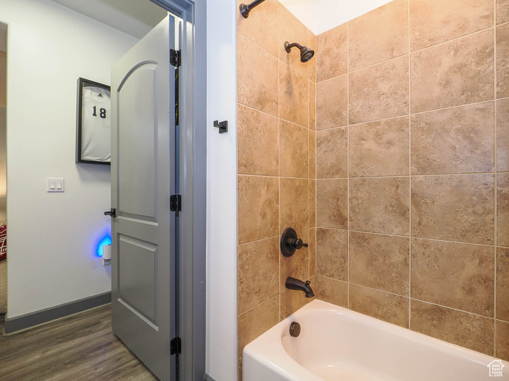 Bathroom featuring tiled shower / bath combo and hardwood / wood-style floors
