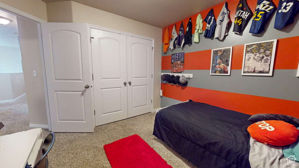 Bedroom featuring light carpet and a closet