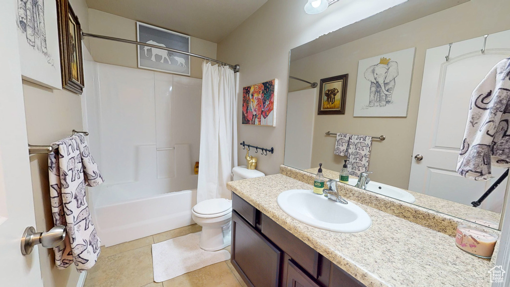 Full bathroom featuring vanity, toilet, tile flooring, and shower / tub combo with curtain