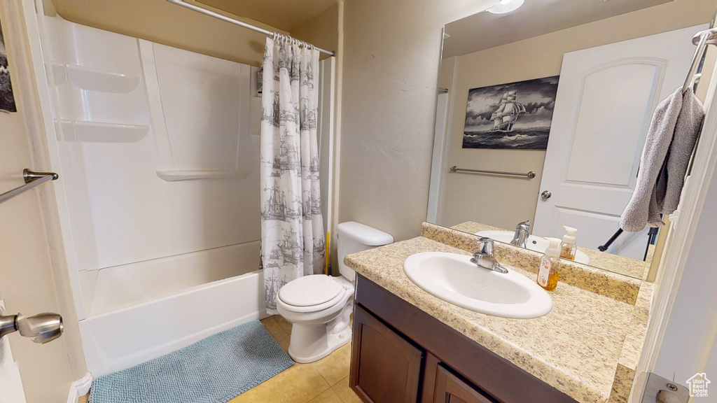 Full bathroom featuring toilet, tile flooring, oversized vanity, and shower / tub combo with curtain