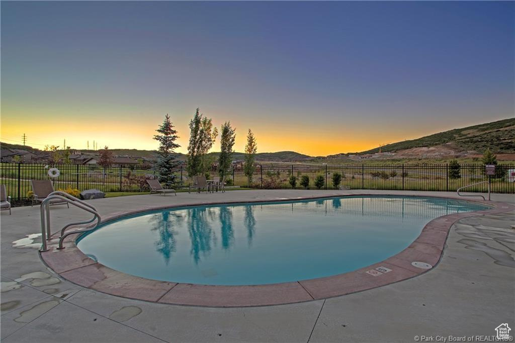 Pool at dusk featuring a mountain view