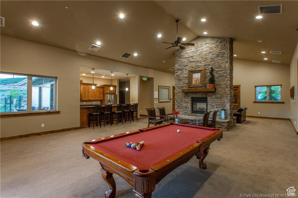 Game room with light colored carpet, ceiling fan, a fireplace, and pool table