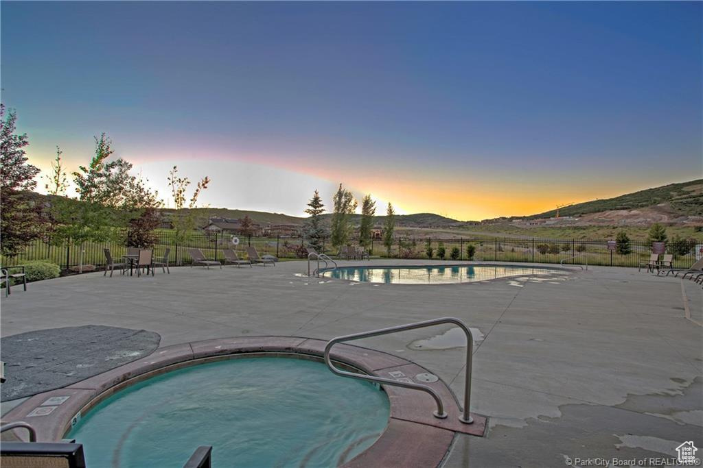 Pool at dusk featuring a patio and a mountain view