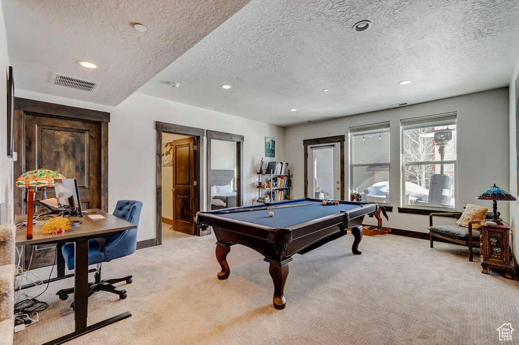 Recreation room featuring light carpet, billiards, and a textured ceiling