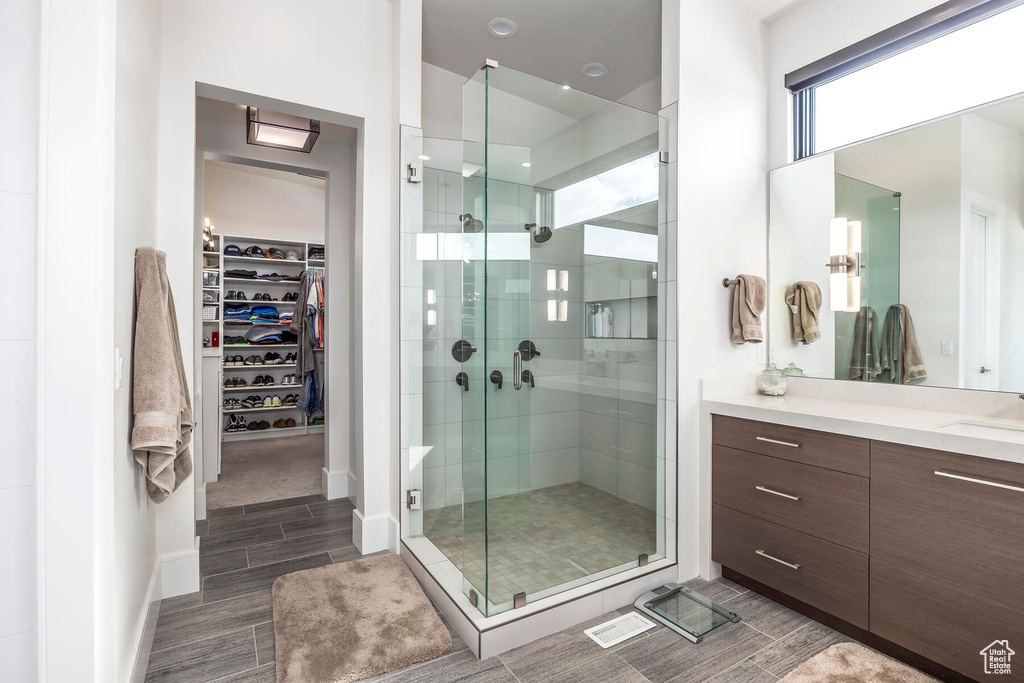 Bathroom with an enclosed shower, tile floors, and vanity