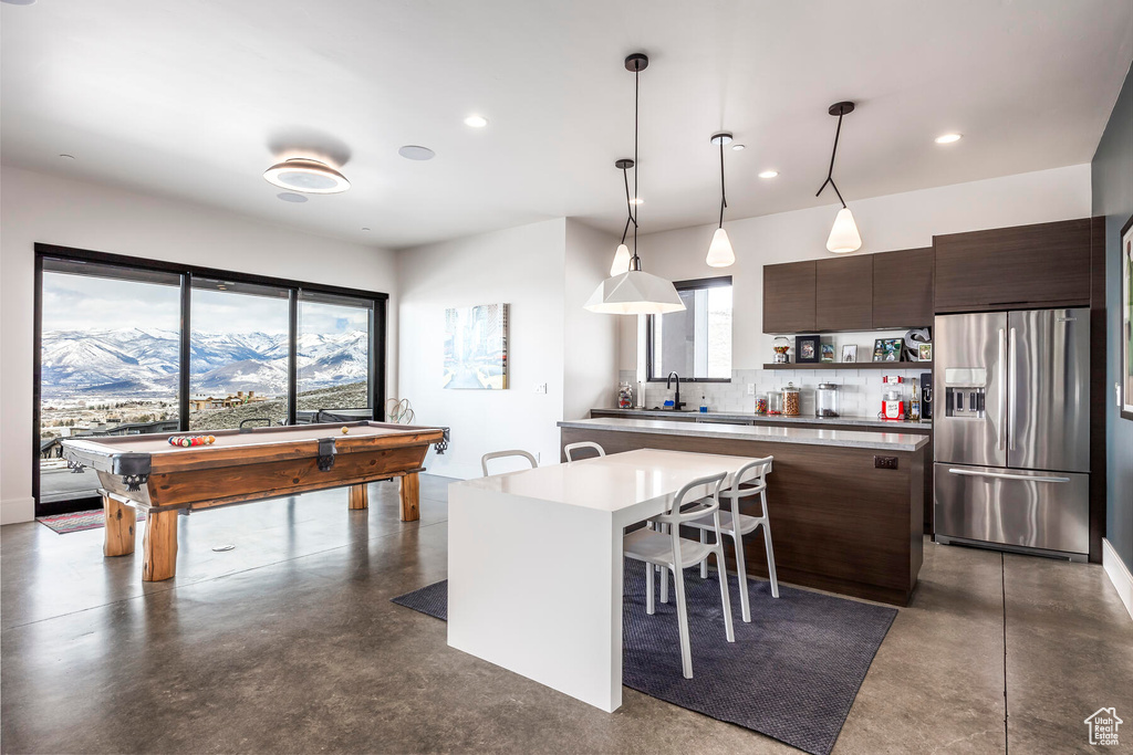 Kitchen featuring tasteful backsplash, a breakfast bar, billiards, a mountain view, and stainless steel refrigerator with ice dispenser