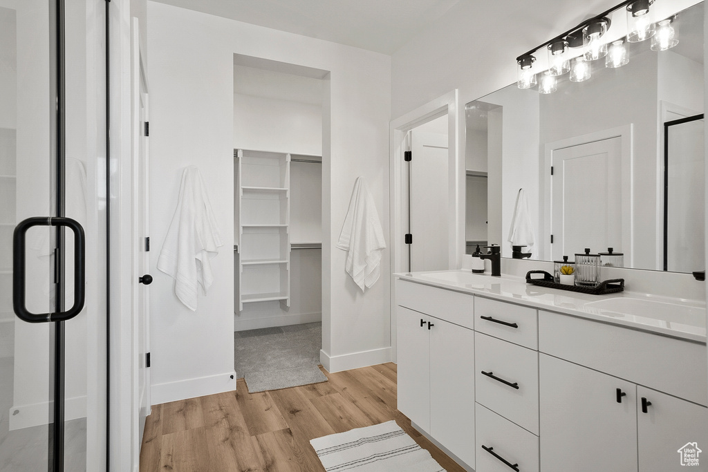 Bathroom with wood-type flooring and dual vanity