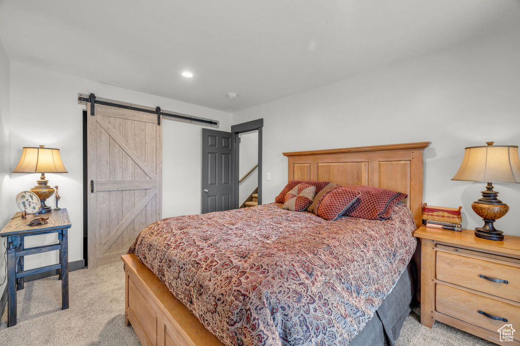 Bedroom featuring light carpet and a barn door