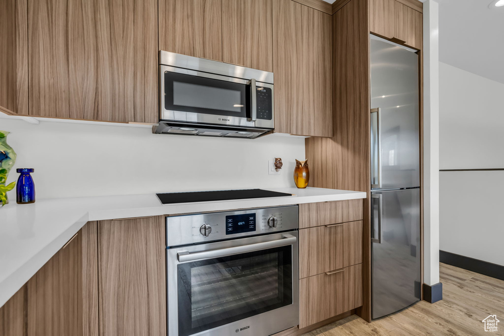 Kitchen featuring appliances with stainless steel finishes and light hardwood / wood-style floors